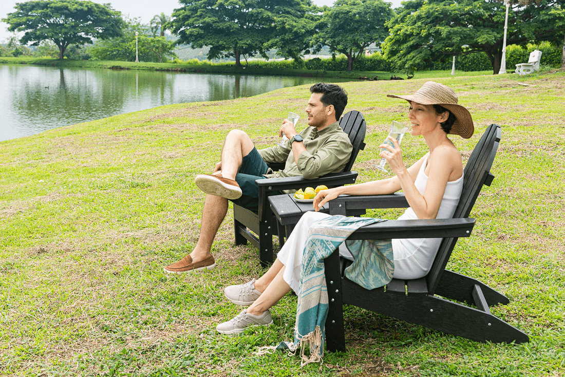 Pareja disfrutando en sillas Adirondack junto al lago